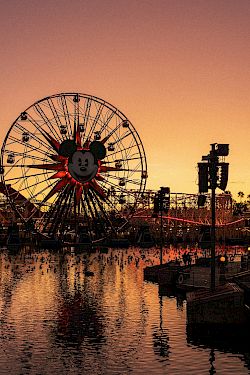 A twilight view of an amusement pier with a glowing ferris wheel, roller coaster, and water reflections along the harbor, in Orange and purple skies.